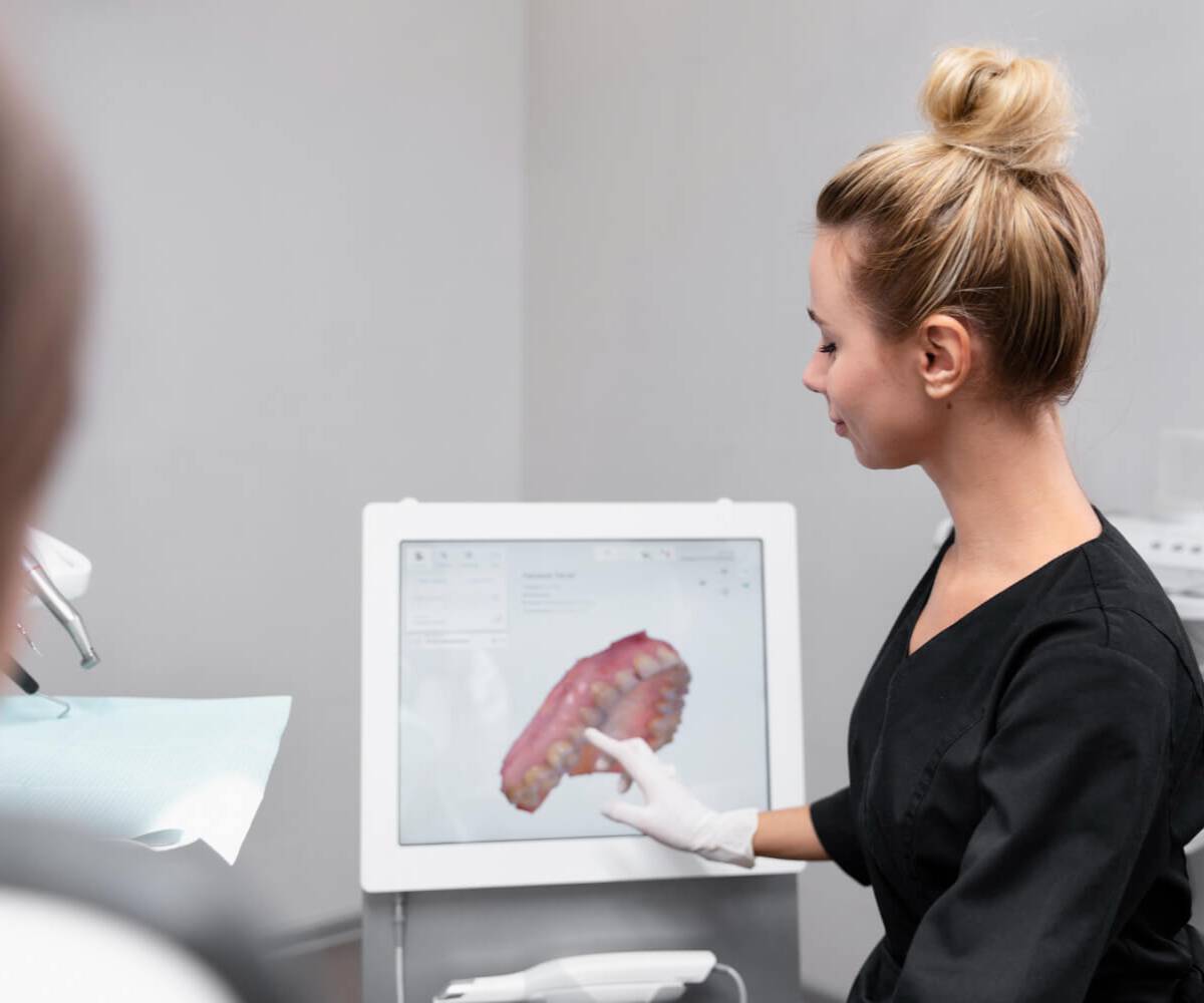 diş doktoru hastasının x ray yazılımından diş röntgenini gösteriyor