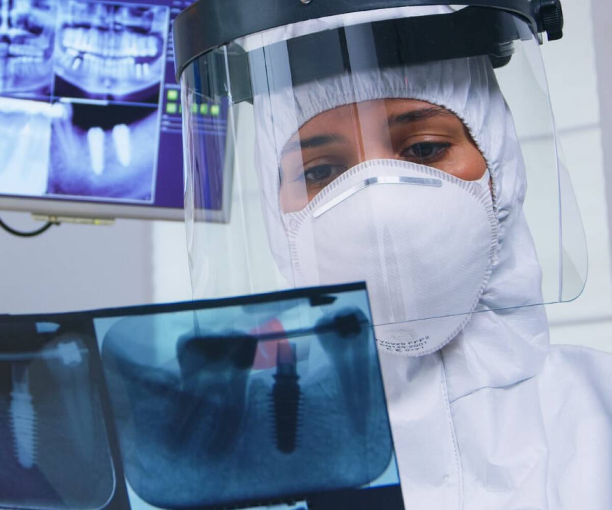 dentist examines a patient's dental imaging report