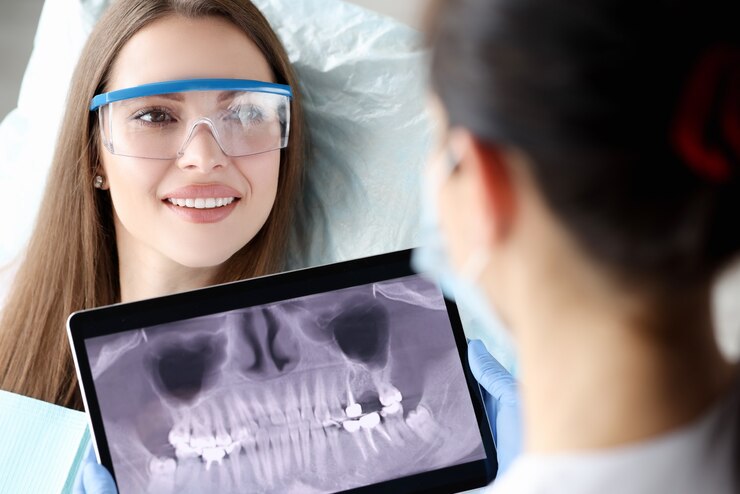 Dentist analyzes dental x-rays from tablet.