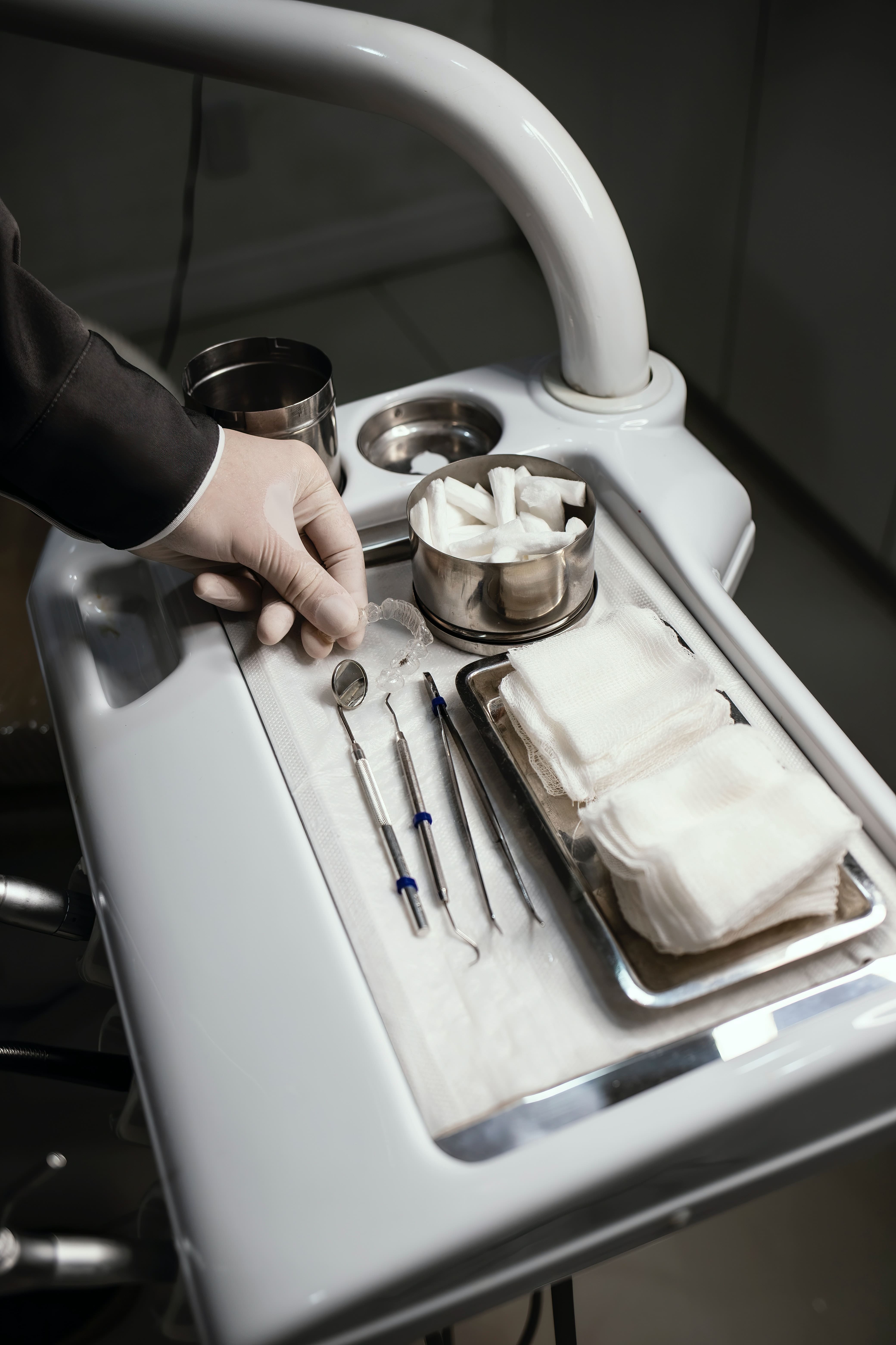 dentist holding transparent aligners and dental instruments on the table