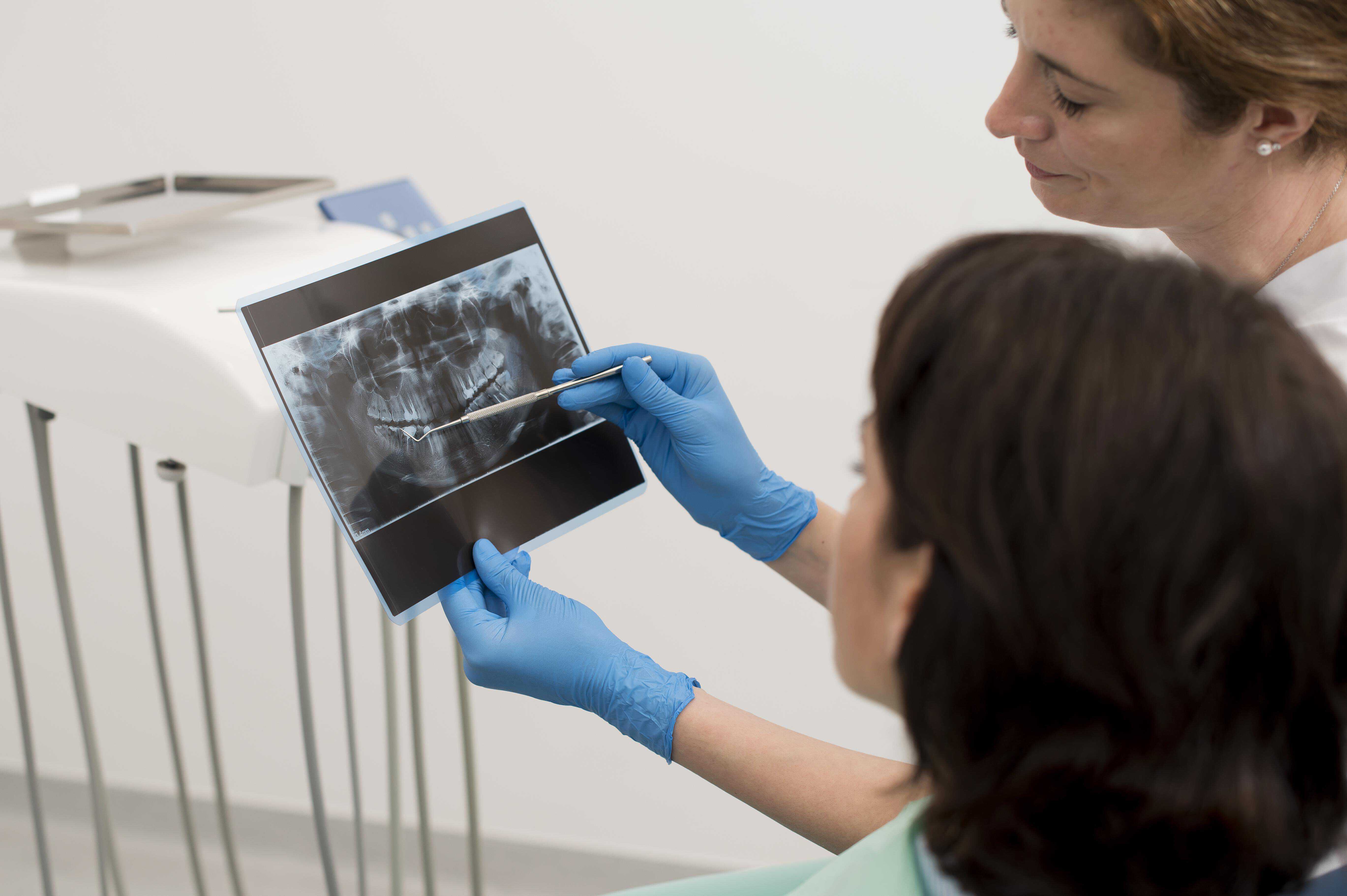 The dentist is providing information to the patient about dental imaging.