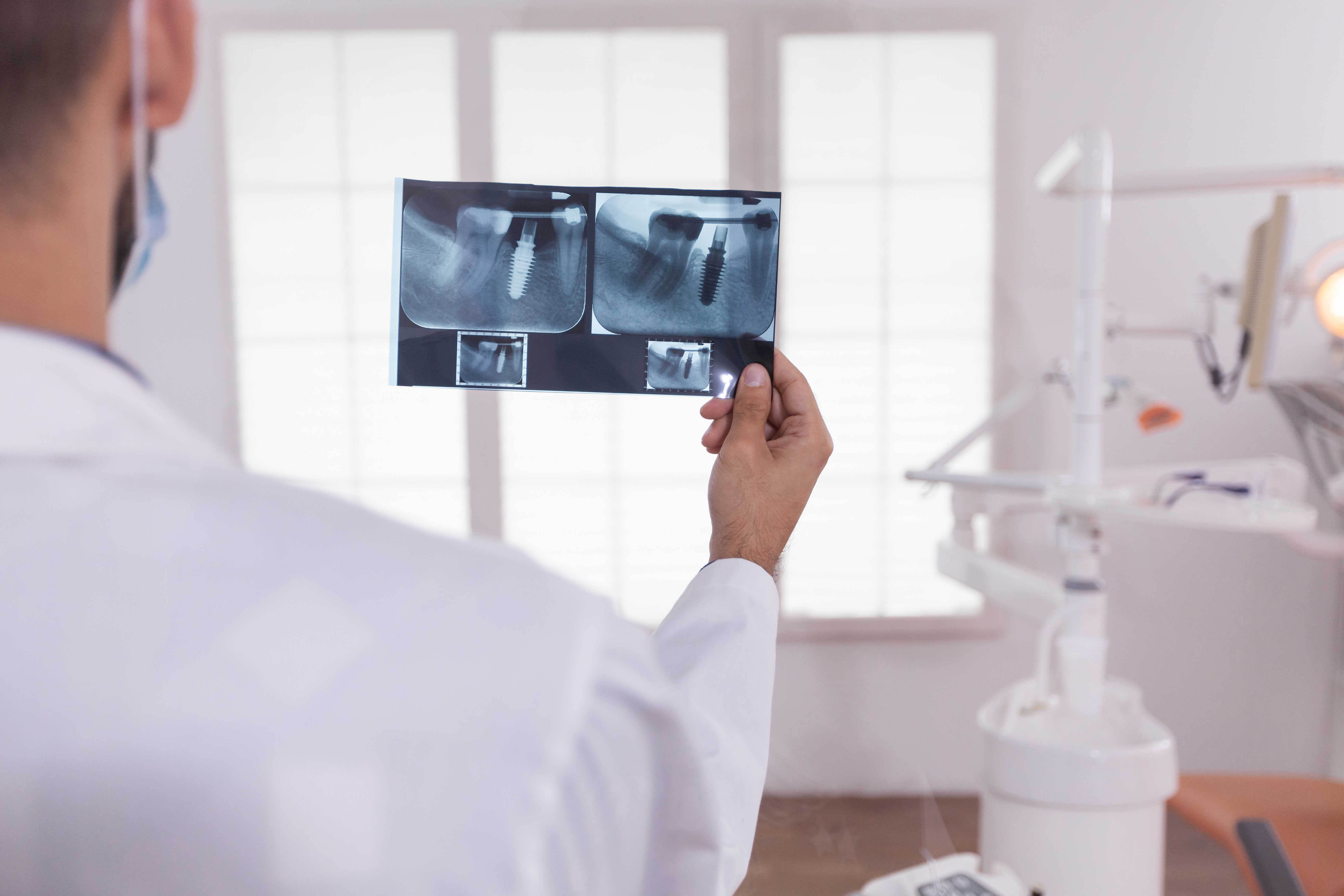 A dentist evaluating dental imaging results for a patient.
