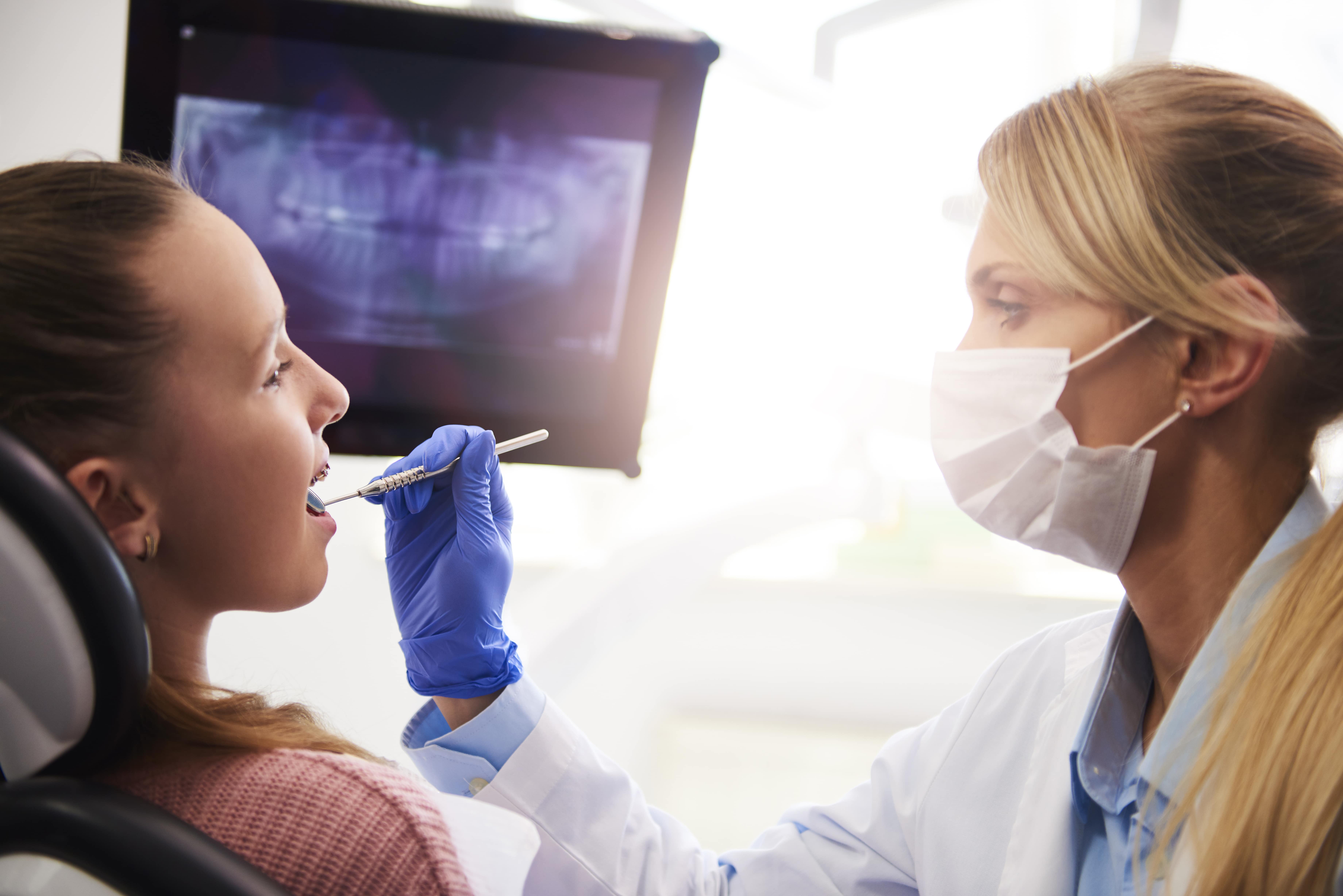 A physician examines a patient based on dental imaging results.