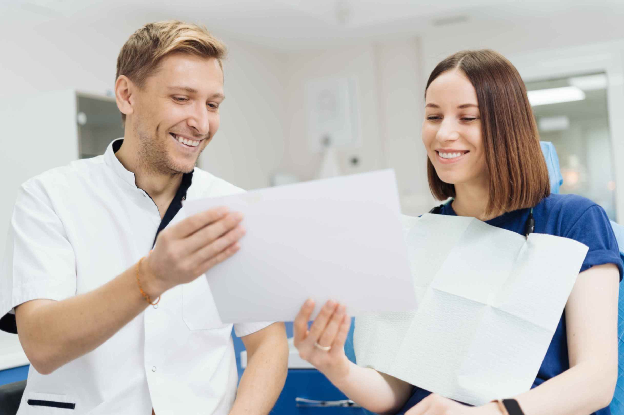 A man with a magnifying glass examines a dental insurance policy