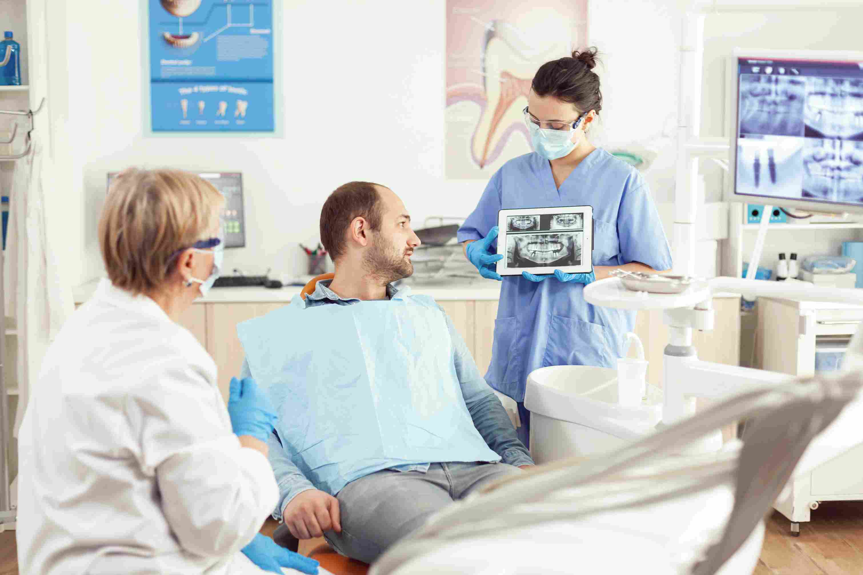 Dentist and patient reviewing a radiograph using artificial intelligence in dental health tourism